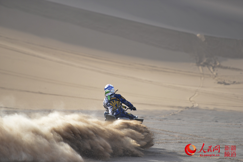 賽車高速駛過，飛馳的車輪卷起沙塵。徐蒙 攝